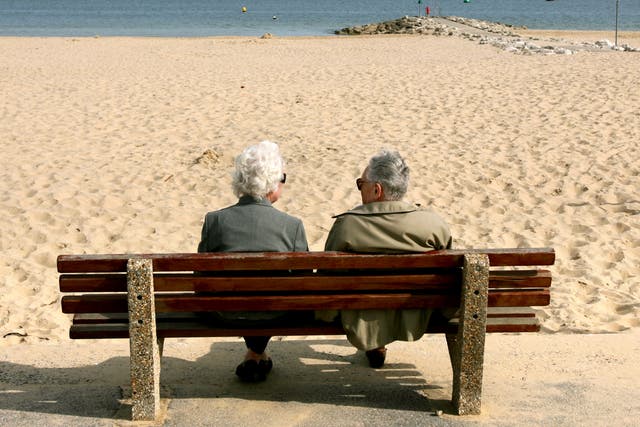 An elderly couple enjoy the sunshine at Sandbanks in Poole, Dorset
