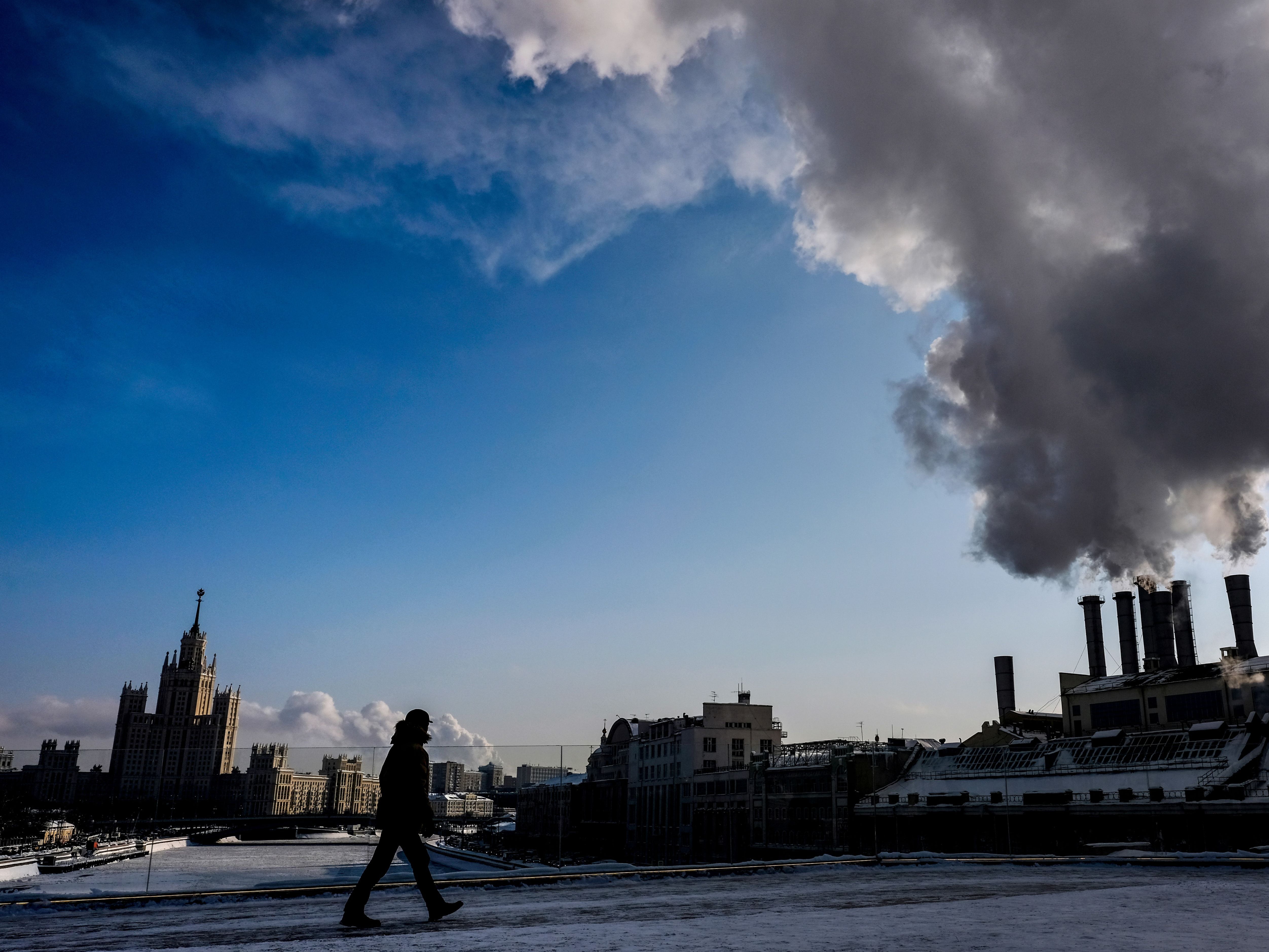 A man walks near the heat electropower station and Stalin’s tower building in Zaryadye park in central Moscow