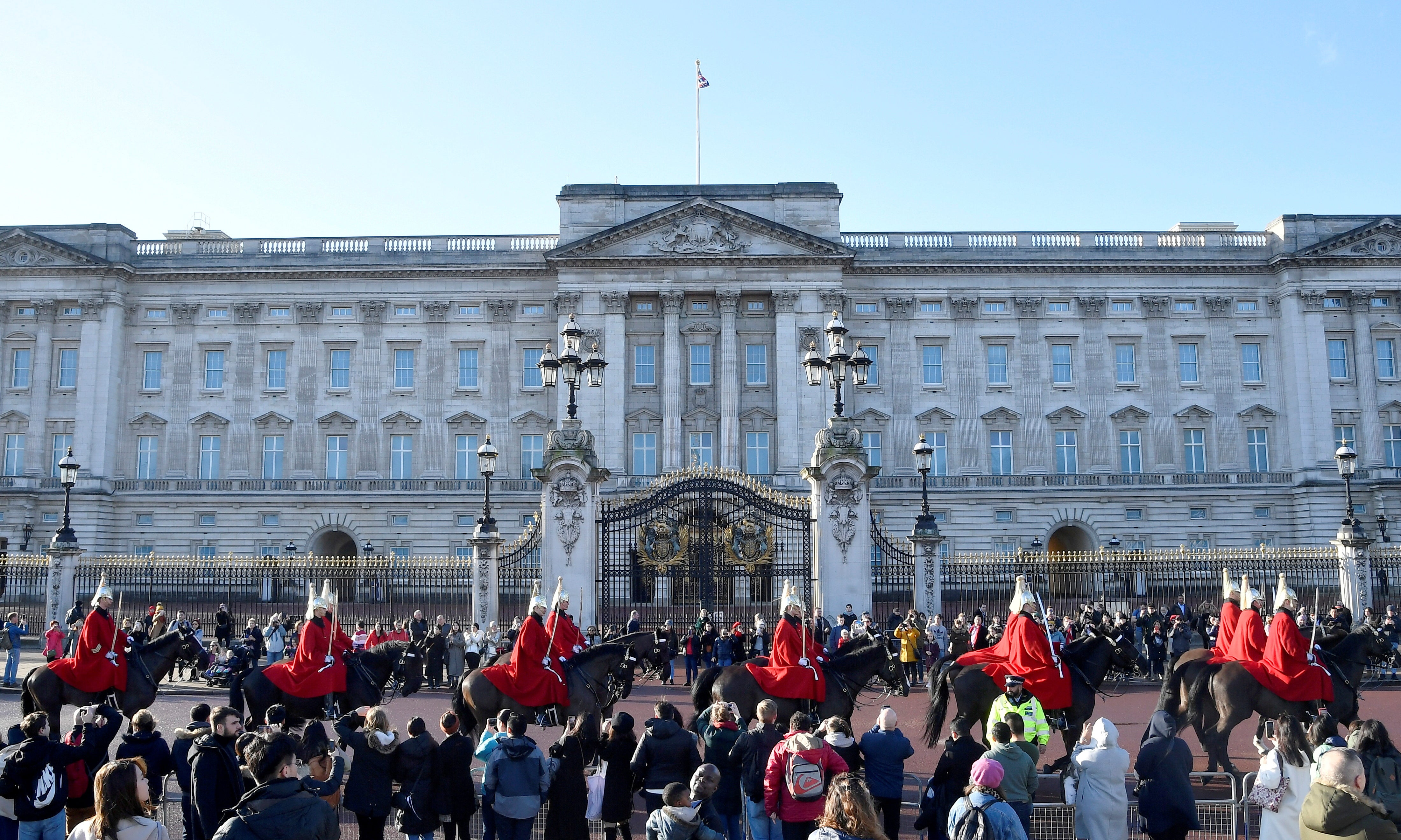 Members of the Household Cavalry ride past Buckingham Palace in January last year
