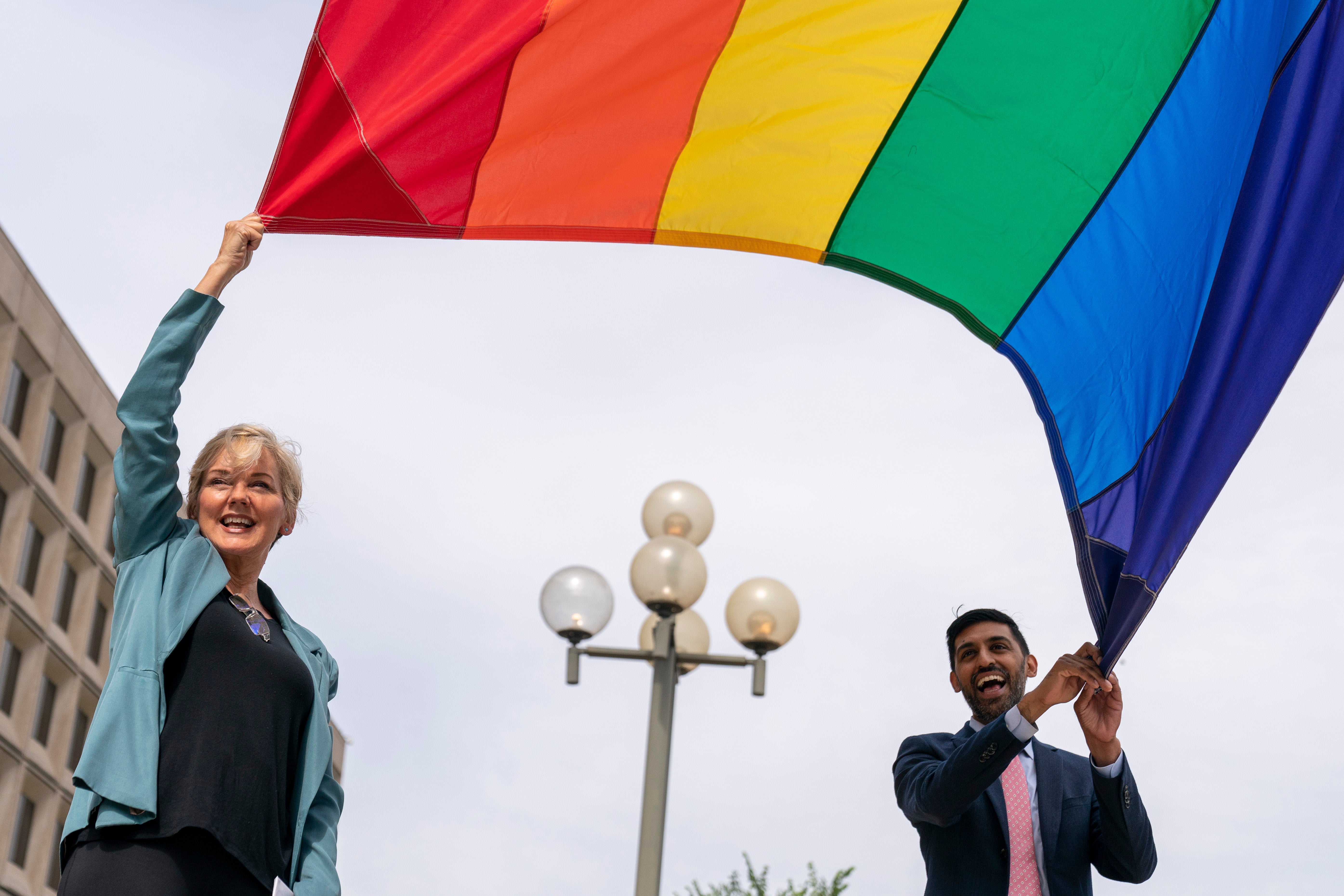 Energy secretary Jennifer Granholm and Department of Energy chief of staff Tarak Shah raise the Pride flag in Washington on Wednesday