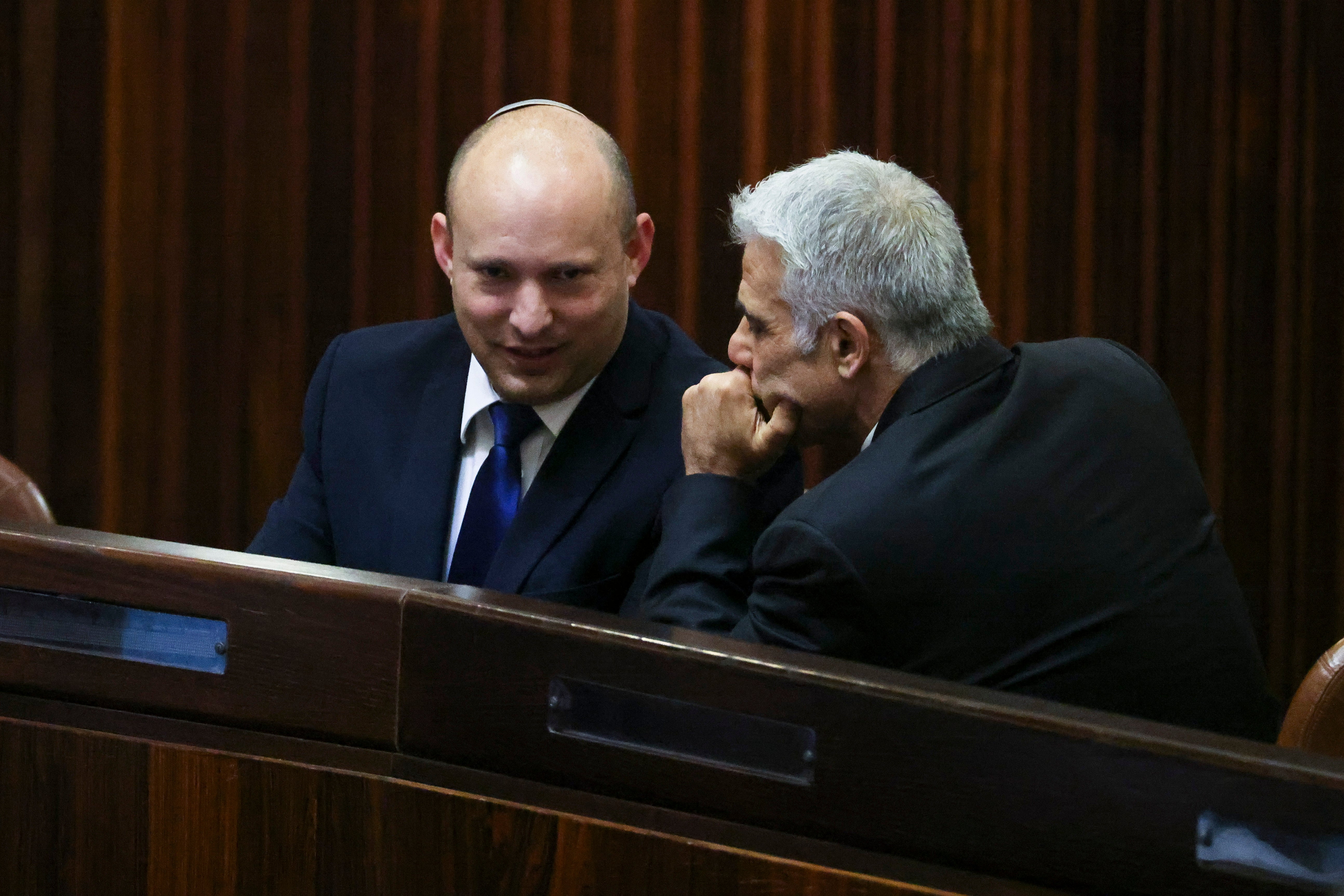 <p>Yamina party leader Naftali Bennett (left) speaks to his Yesh Atid counterpart Yair Lapid in the Knesset, in Jerusalem, on Wednesday</p>
