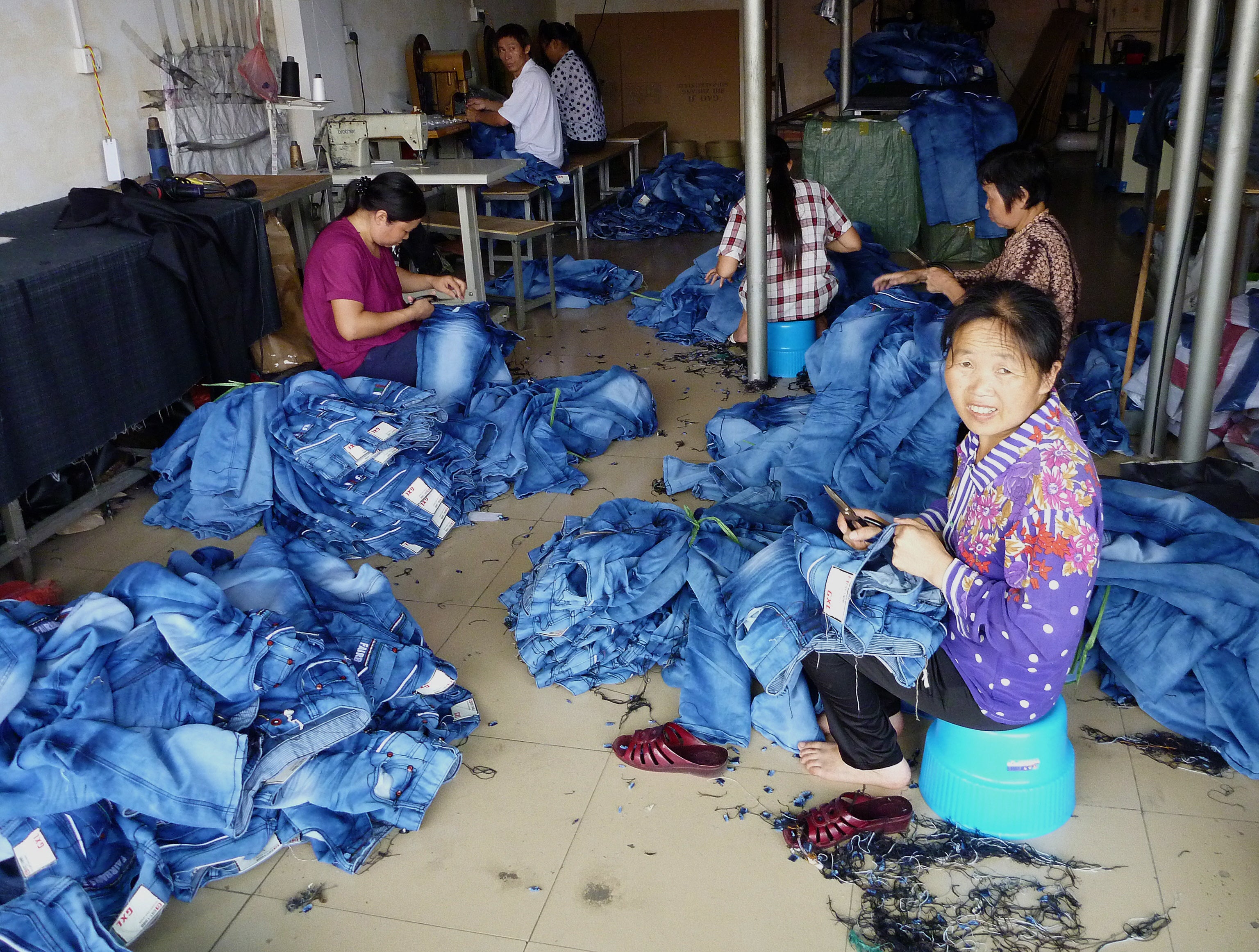 Workers stitch jeans at a small factory in Zengcheng, Guangdong Province