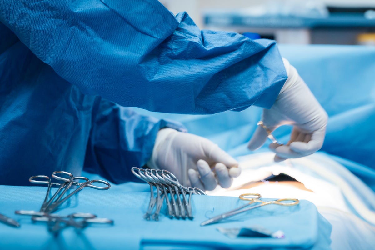 Doctor who posted image of himself performing brain surgery on dating website struck off