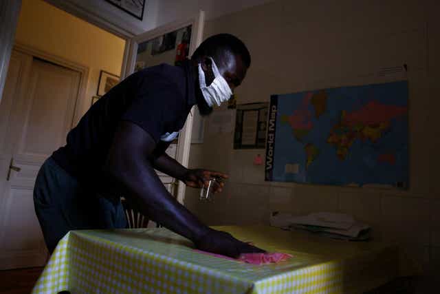<p>Frank Agbontaen, from Nigeria, cleans a kitchen in Rome</p>