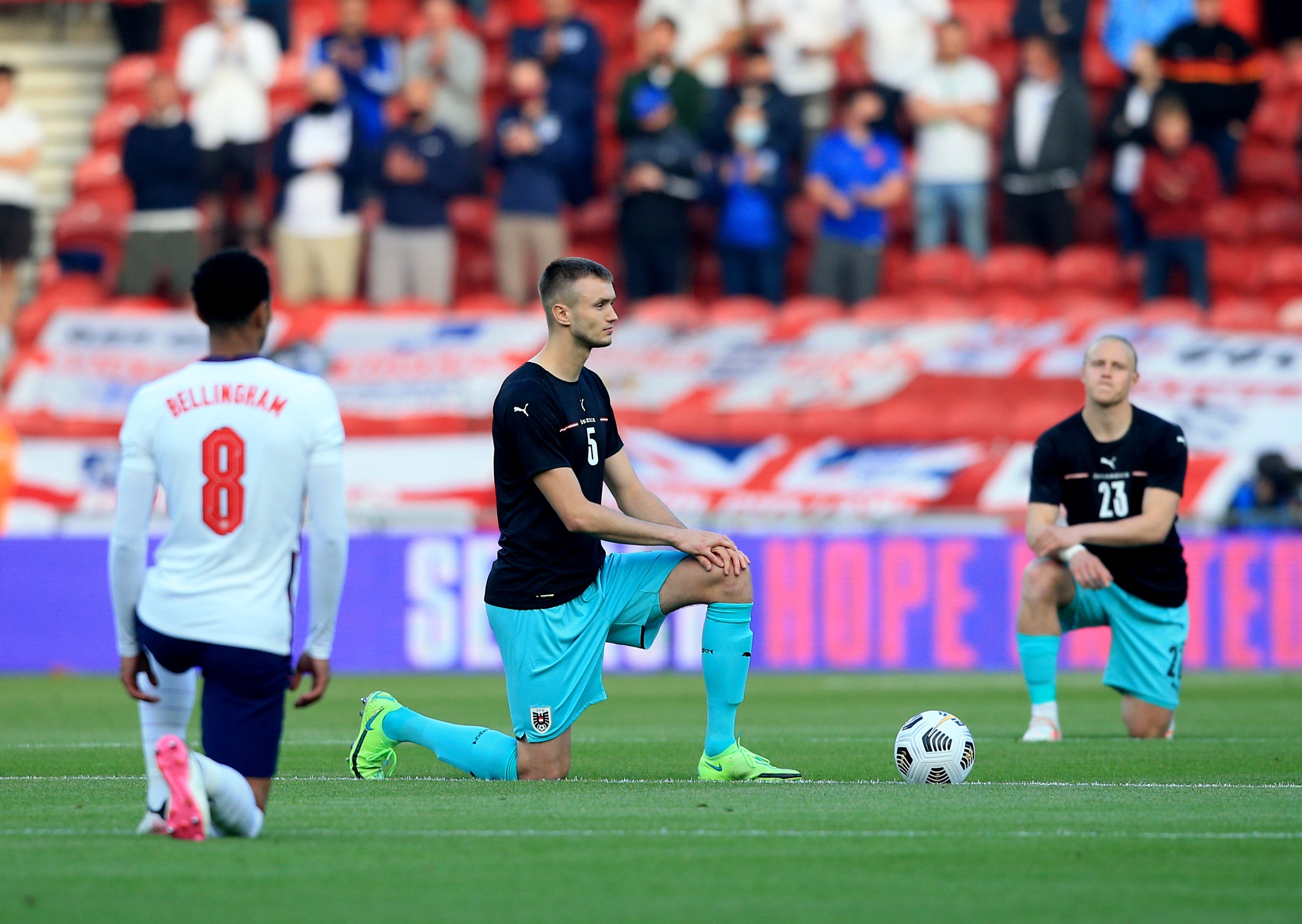 England's Jude Bellingham and Austria’s Sasa Kalajdzic take the knee before kick-off