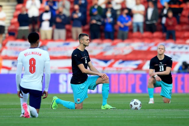 England's Jude Bellingham and Austria’s Sasa Kalajdzic take the knee before kick-off