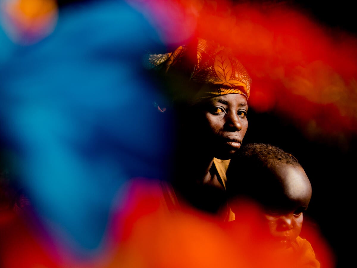 Andrea, 32, sits for a portrait with her baby in an IDP camp