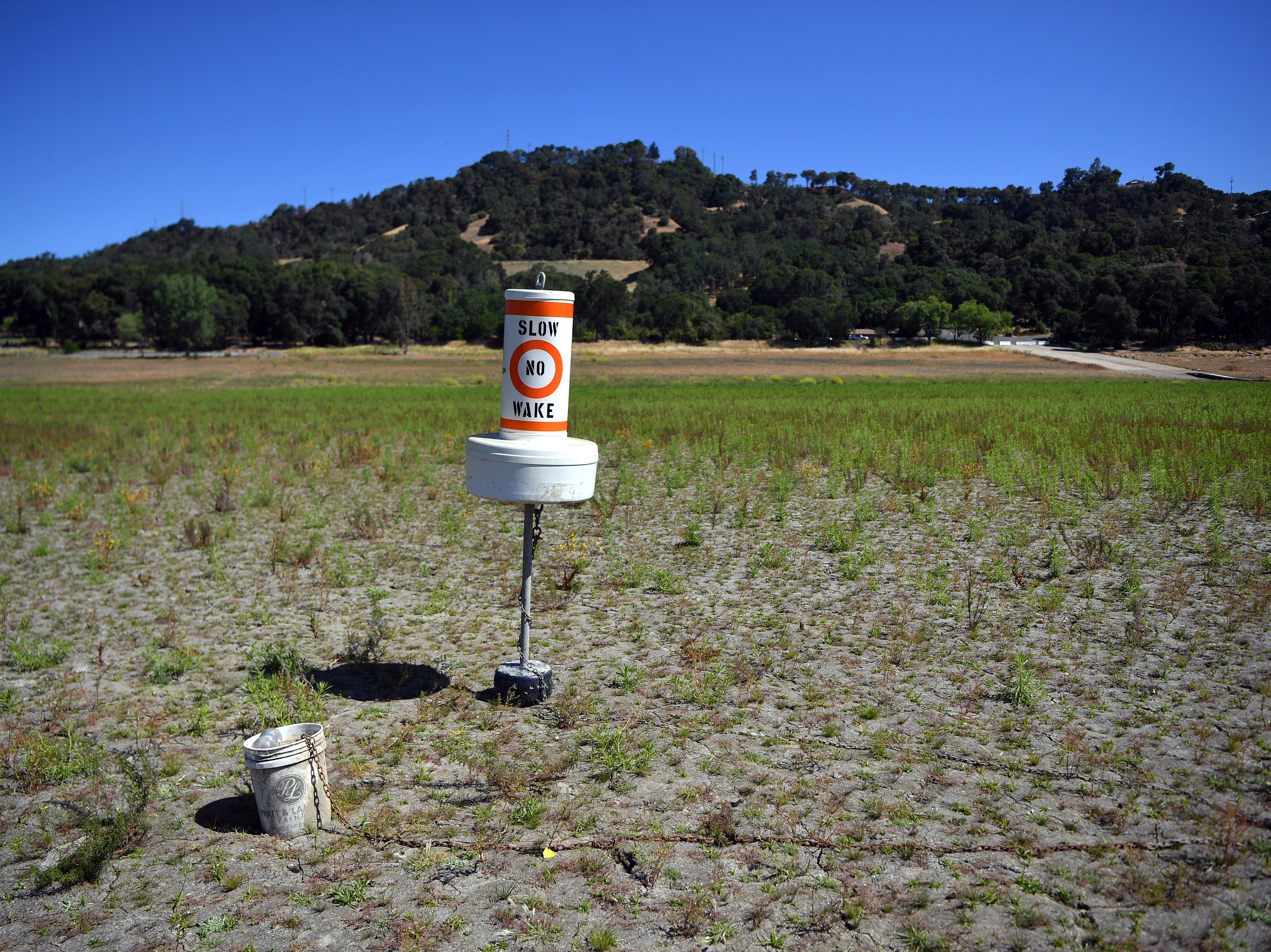 A buoy sits on dry land that had been under water, at a drought-stricken Lake Mendocino, currently at 29 per cent of it normal capacity, in Ukiah, California on Sunday, 23 May 2021