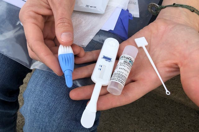 <p>In this Tuesday, March 9, 2021  photo, Solutions Oriented Addiction Response organizer Brooke Parker holds an HIV testing kit in Charleston, W.Va.</p>