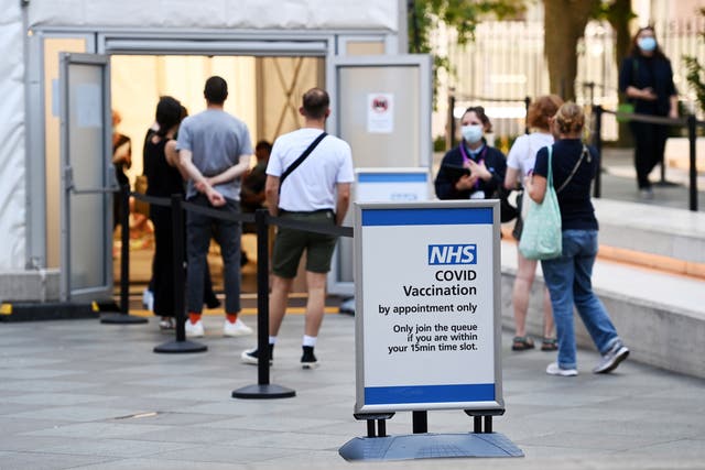 <p>People enter a Covid-19 vaccination centre in London</p>