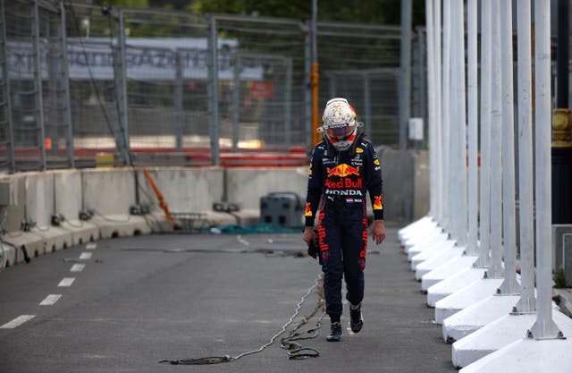 Red Bull's Max Verstappen walks off the track after crashing out five laps from the end of the Azerbaijan Grand Prix following a tyre failure