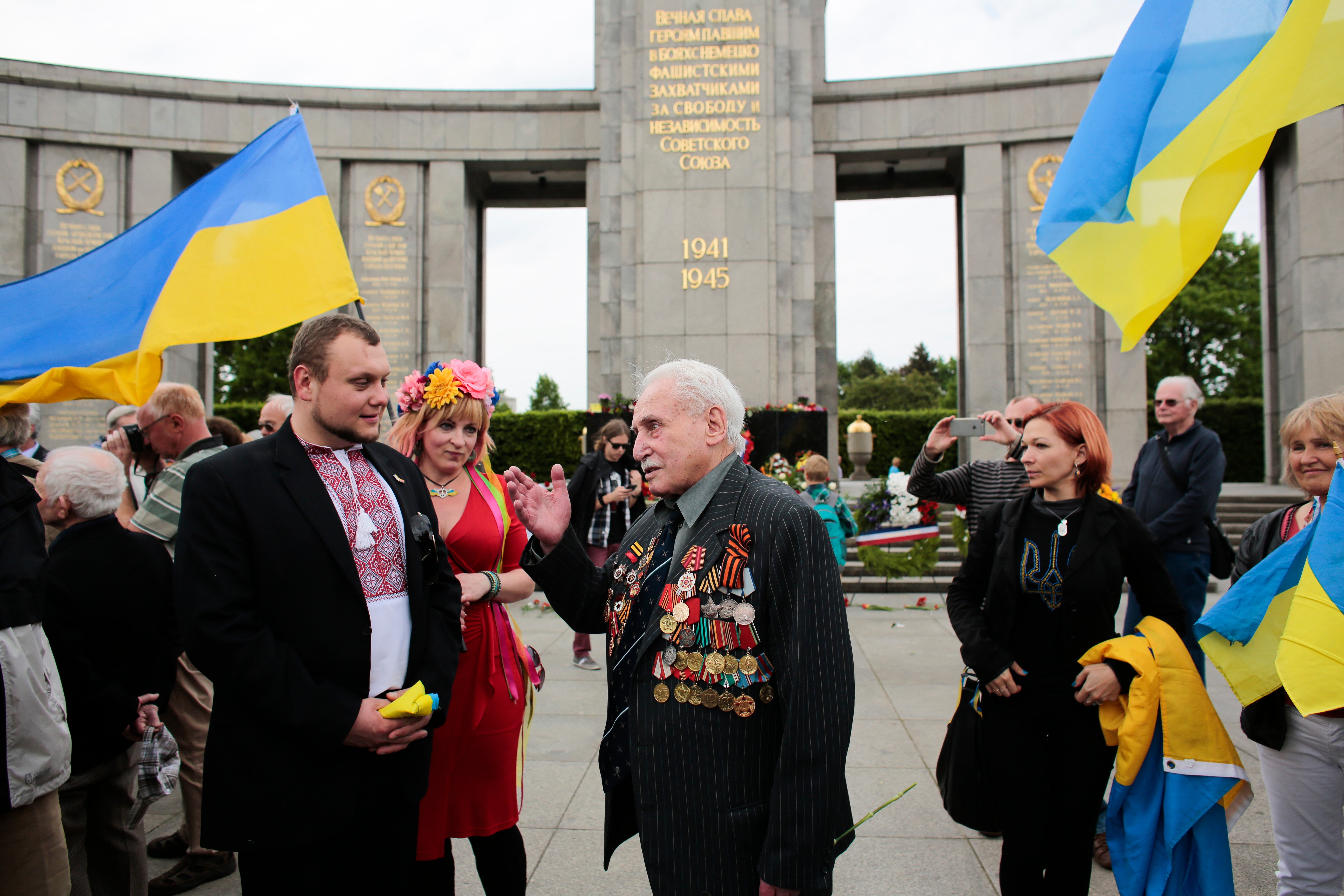 File: In this Friday, 8 May 2015 file photo, Soviet war veteran David Dushman, 92, center, speaks to people holding Ukrainian flags as he attends a wreath laying ceremony at the Russian War Memorial in the Tiergarten district of Berlin, Germany