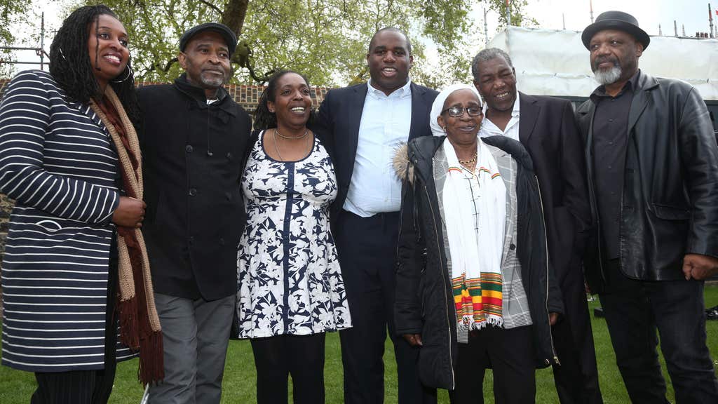 Anthony Bryan flanked by fellow Windrush survivors, MPs Dawn Butler and David Lammy.