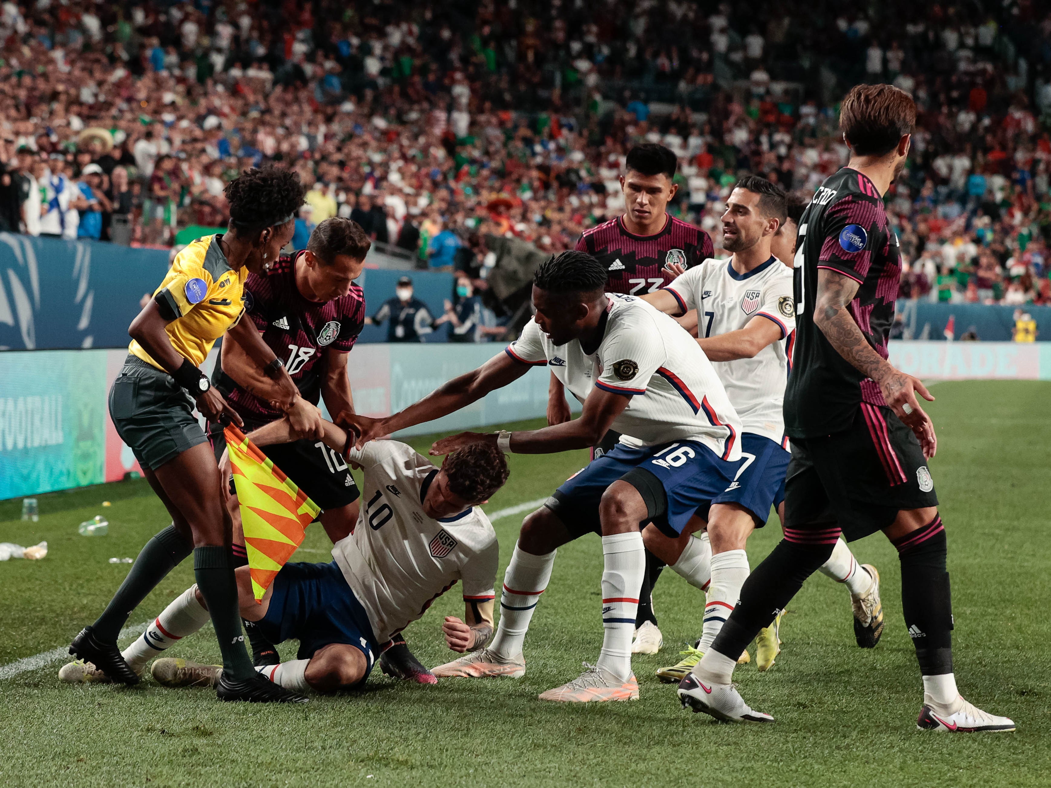 Assistant referee Jassett Kerr intervenes in extra time during the 2021 CONCACAF Nations League Finals soccer series final match at Empower Field at Mile High.