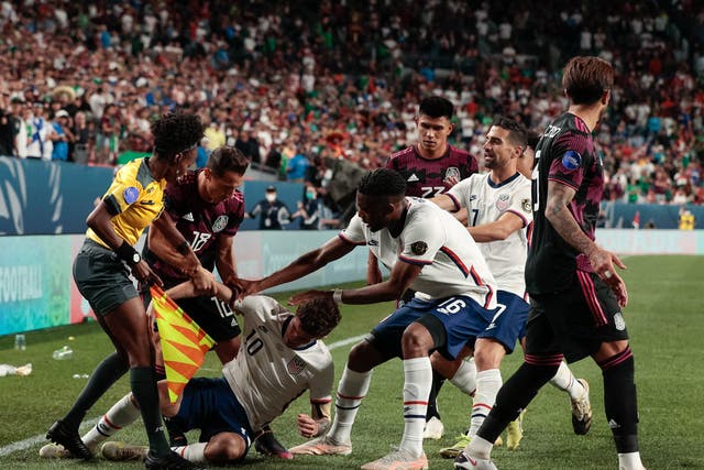 <p>Assistant referee Jassett Kerr intervenes in extra time during the 2021 CONCACAF Nations League Finals soccer series final match at Empower Field at Mile High.</p>
