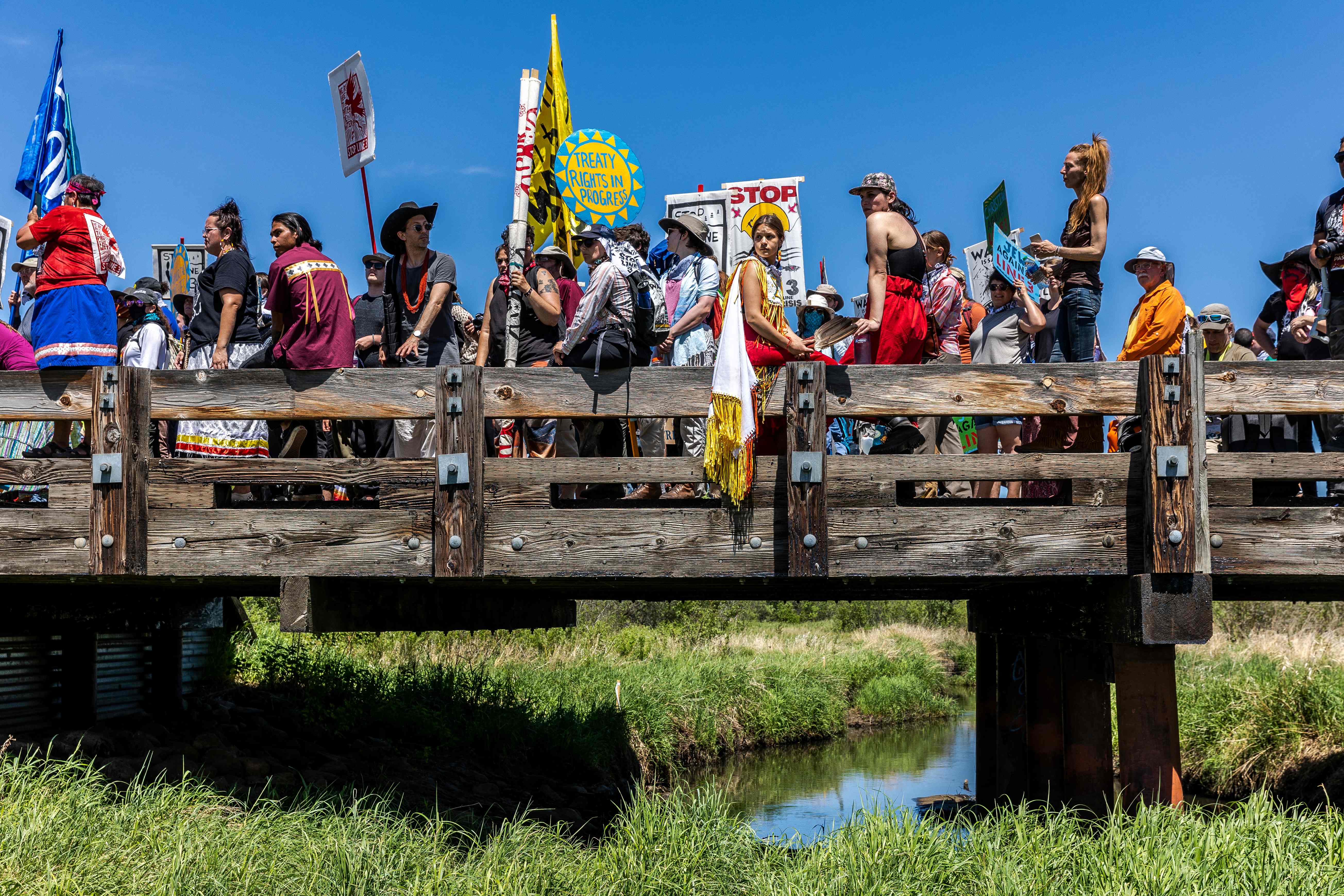 Climate activist and Indigenous community members gather on top of the bridge after taking part in a traditional water ceremony during a rally and march to protest the construction of Enbridge Line 3 pipeline in Solvay, Minnesota on 7 June, 2021