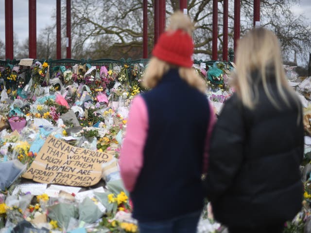 <p>People view floral tributes left at the bandstand in Clapham Common, London, for Sarah Everard</p>