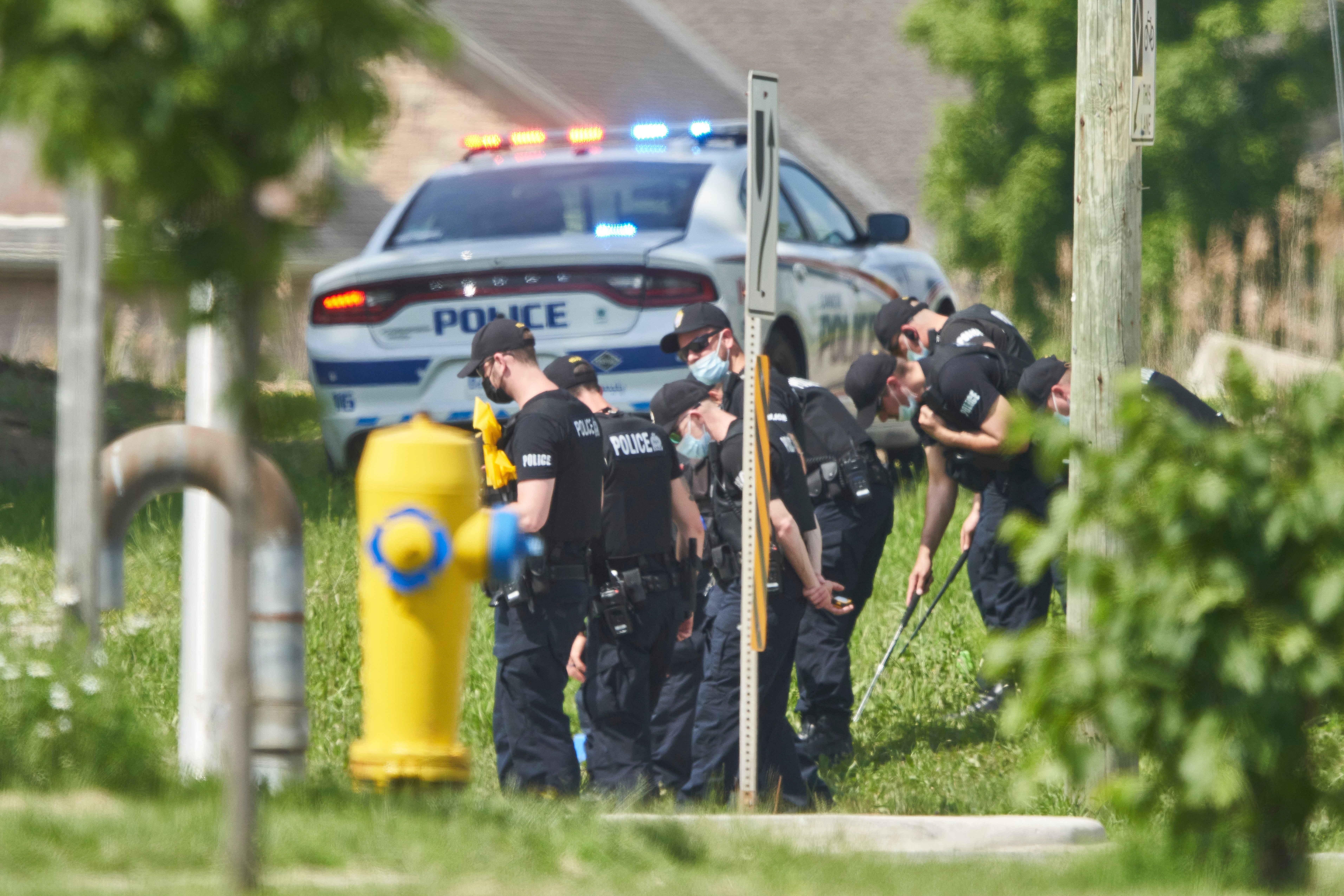 Police officers look for evidence in London, Ontario, after four members of a Muslim family were killed by a truck