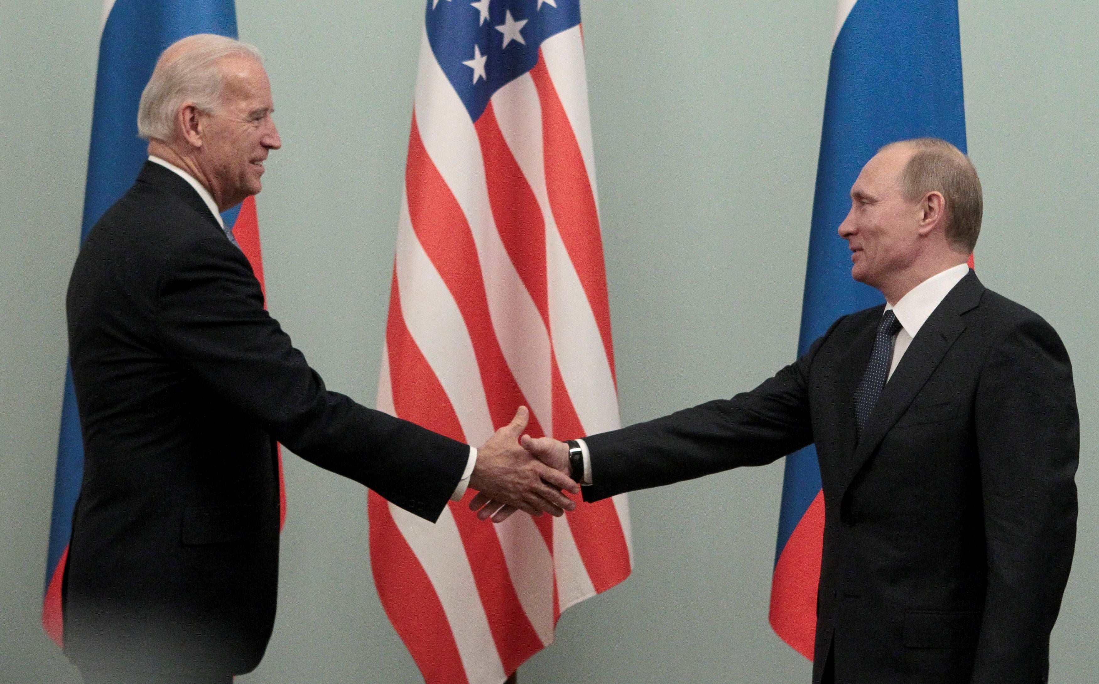 Vladimir Putin (R) shakes hands with then US vice president Joe Biden during their meeting in Moscow in 2011