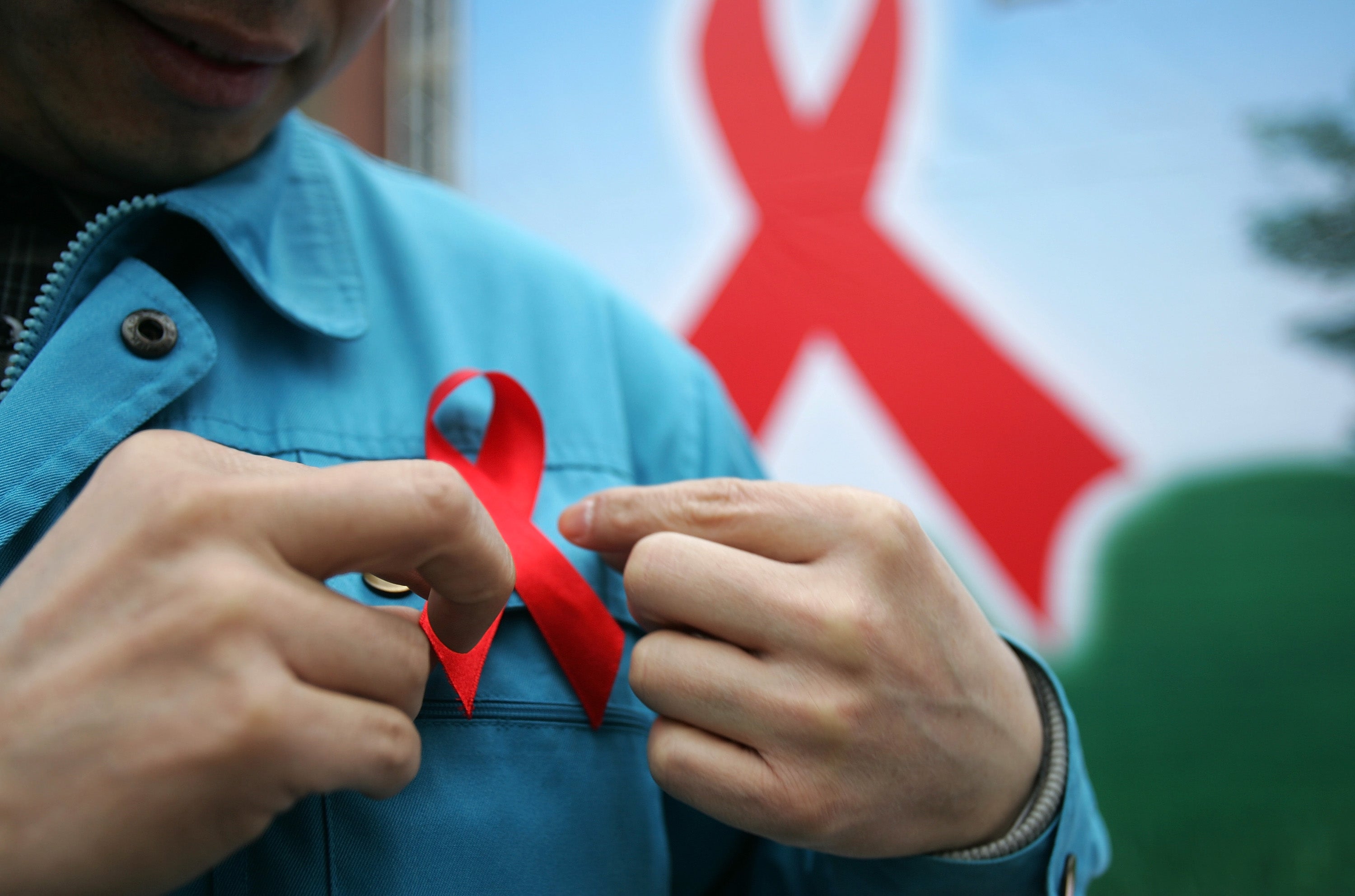 A migrant worker dons a red ribbon during an event to promote HIV/Aids knowledge in China in 2005