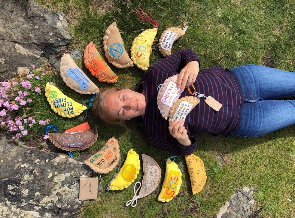 <p>Extinction Rebellion supporter Sarah White surrounded by knitted pasties</p>