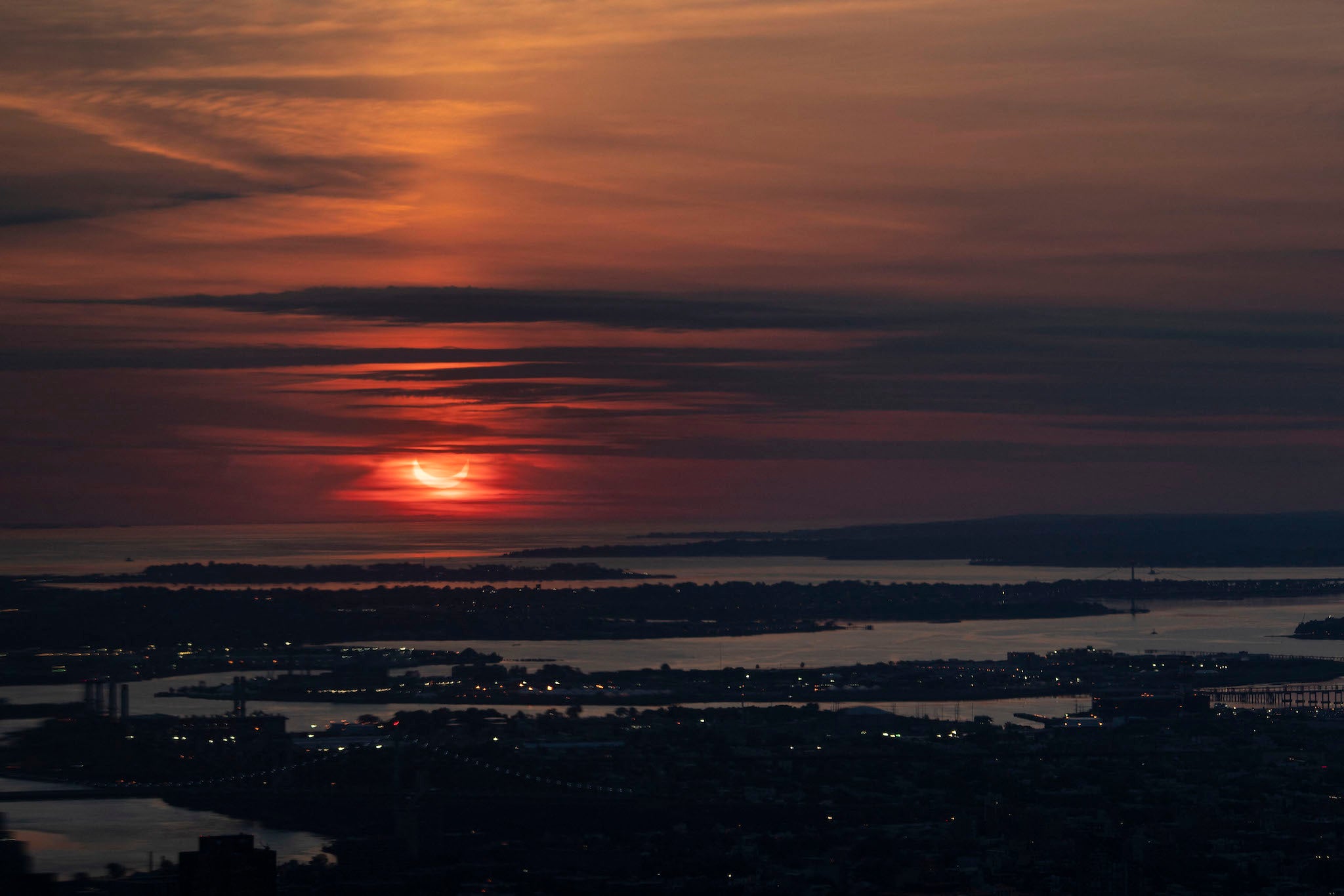 The sun rises partially eclipsed in a view taken from Summit One Vanderbilt