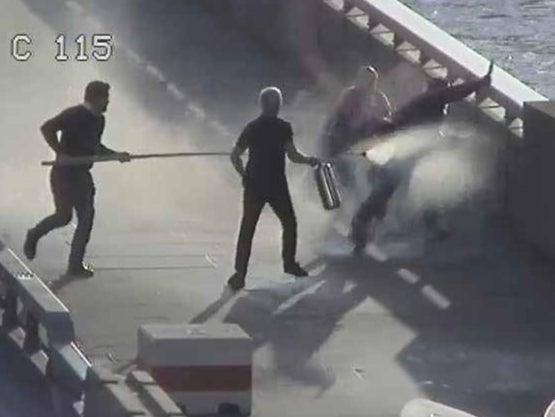 A still of CCTV footage showing John Crilly and Steven Gallant fighting Usman Khan on London Bridge, using a narwhal tusk and fire extinguisher