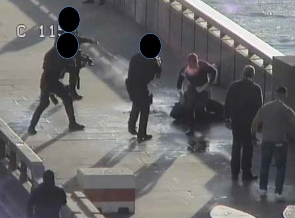 <p>A still from CCTV footage showing armed police officers confronting Usman Khan after he was subdued by members of the public</p>