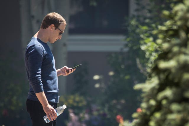 Mark Zuckerberg, chief executive officer of Facebook, checks his phone during the annual Allen & Company Sun Valley Conference, July 13, 2018 in Sun Valley, Idaho