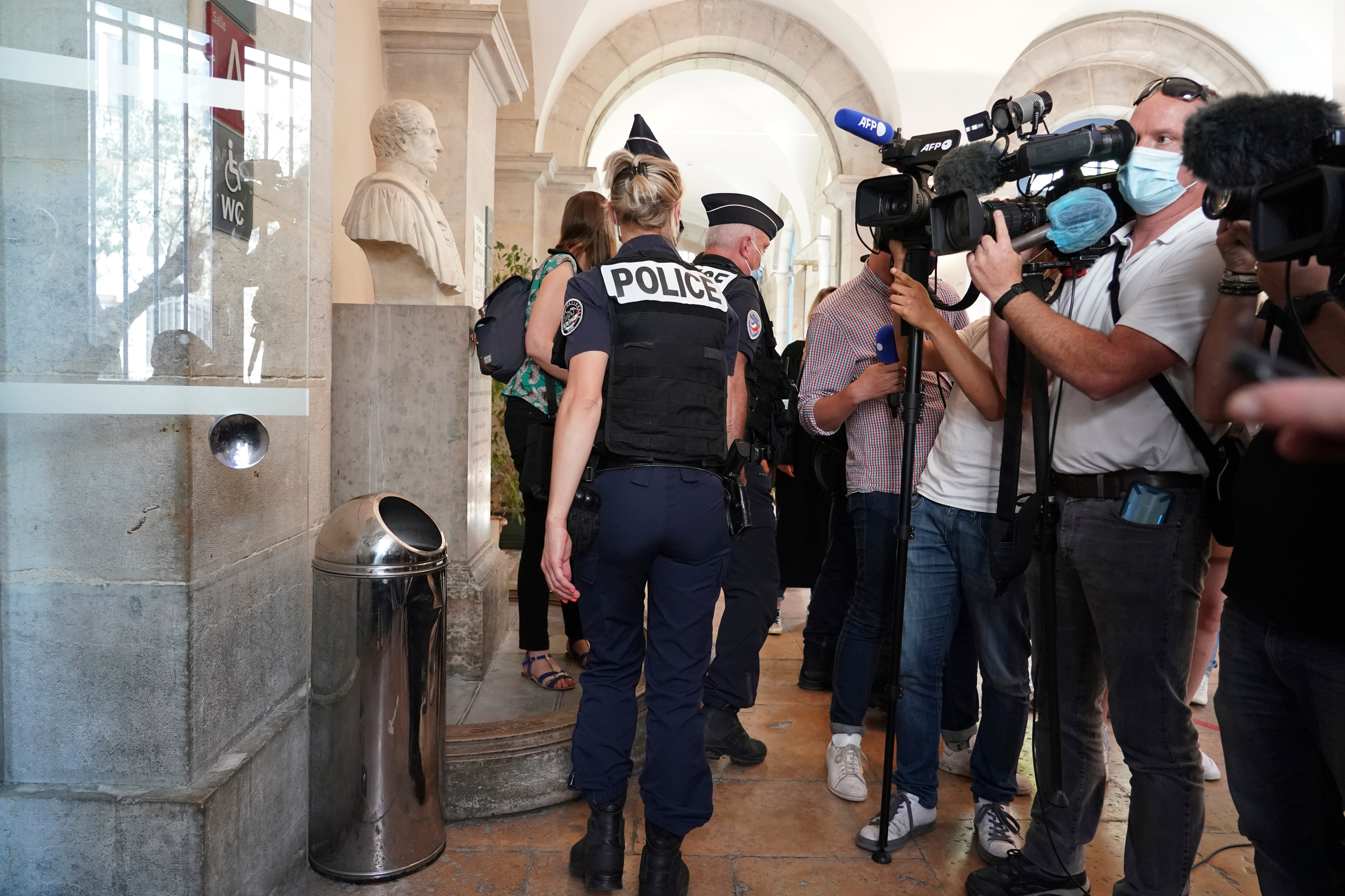 Police officers leave the courtroom as the man who slapped French President Emmanuel Macron is tried, Thursday, June 10, 2021 in Valence, central France.