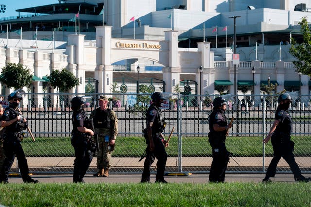 <p>Members of the Louisville Metro Police Department and Kentucky National Guard march in front of Churchill Downs during a protest against the death of Breonna Taylor on Kentucky Derby weekend in Louisville, Kentucky on September 5, 2020</p>