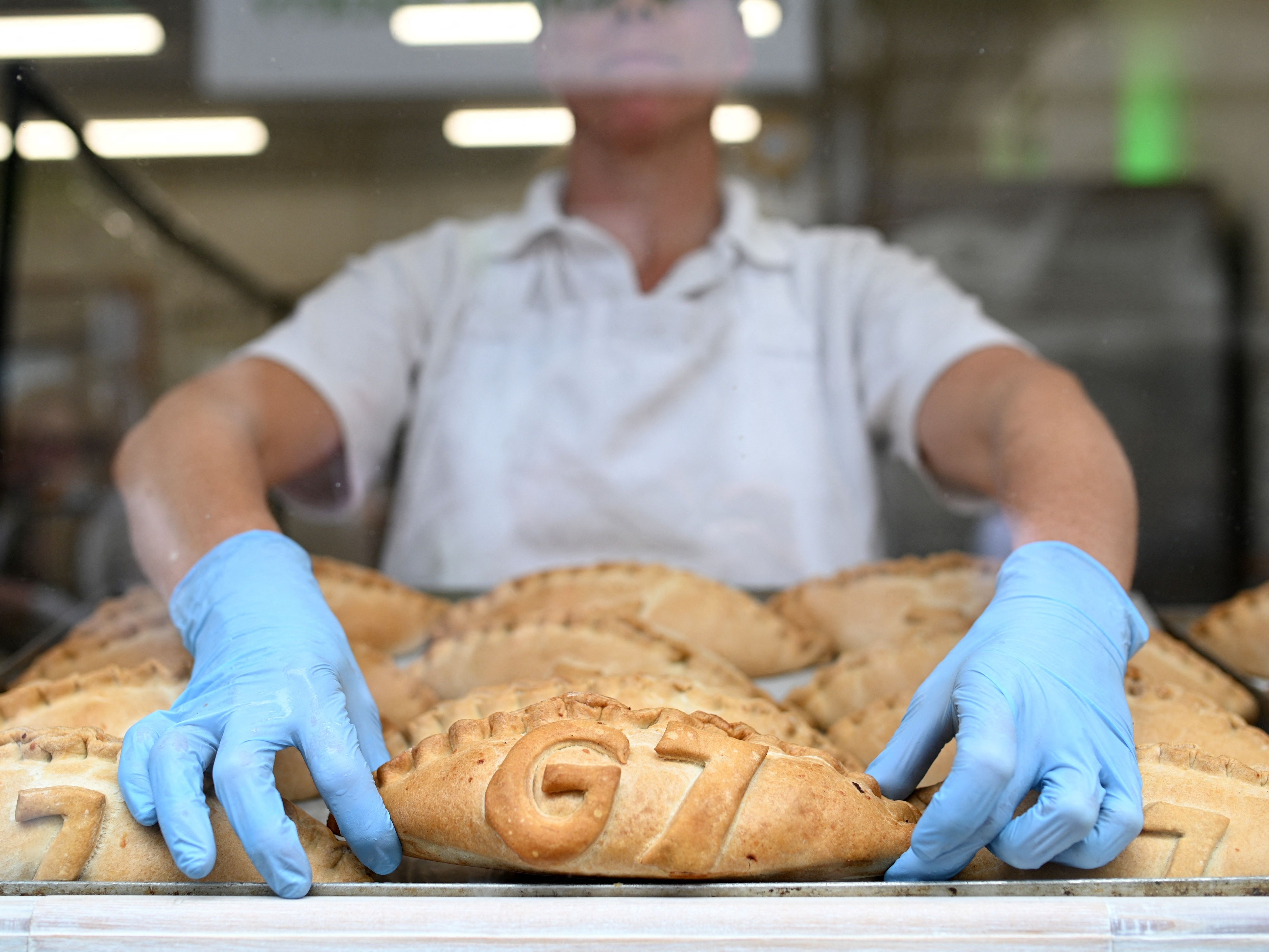 Freshly baked G7 Cornish pasties are placed in the window of a pastry shop in St Ives, Cornwall