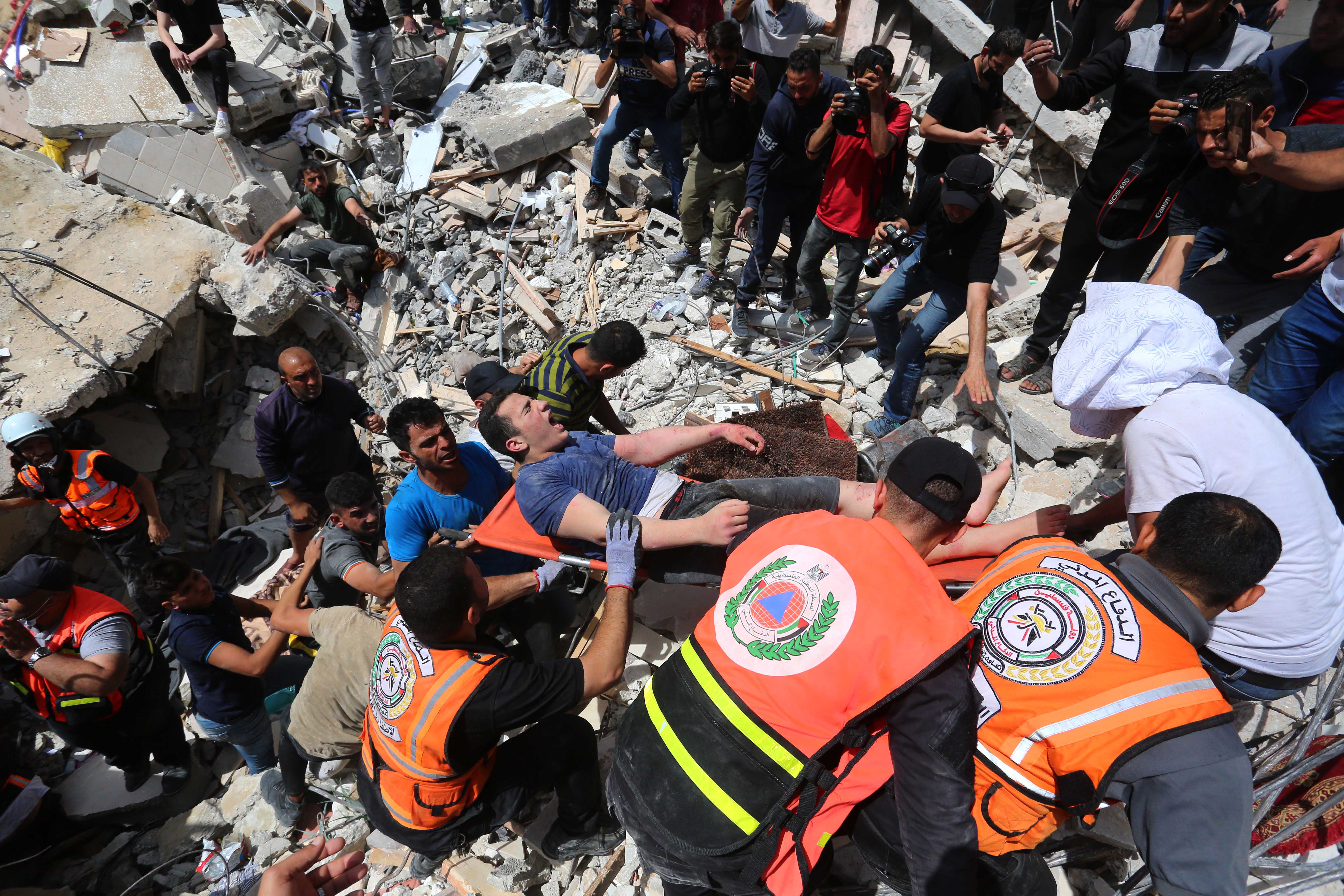 Rescue workers pull surivors from the rubble of the Abu al-Auf building