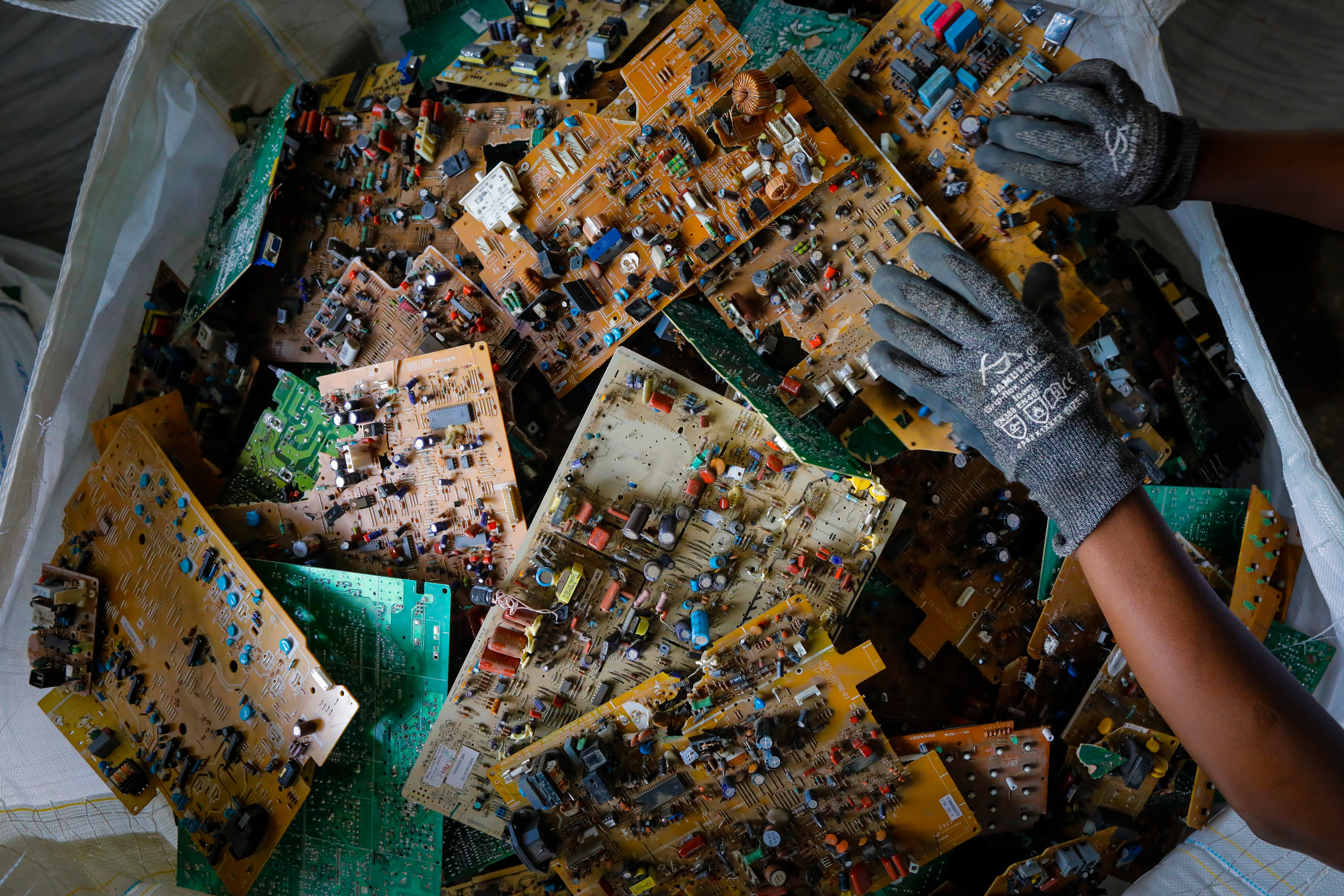 A worker prepares motherboards in Kenya to be shipped to Europe for recycling
