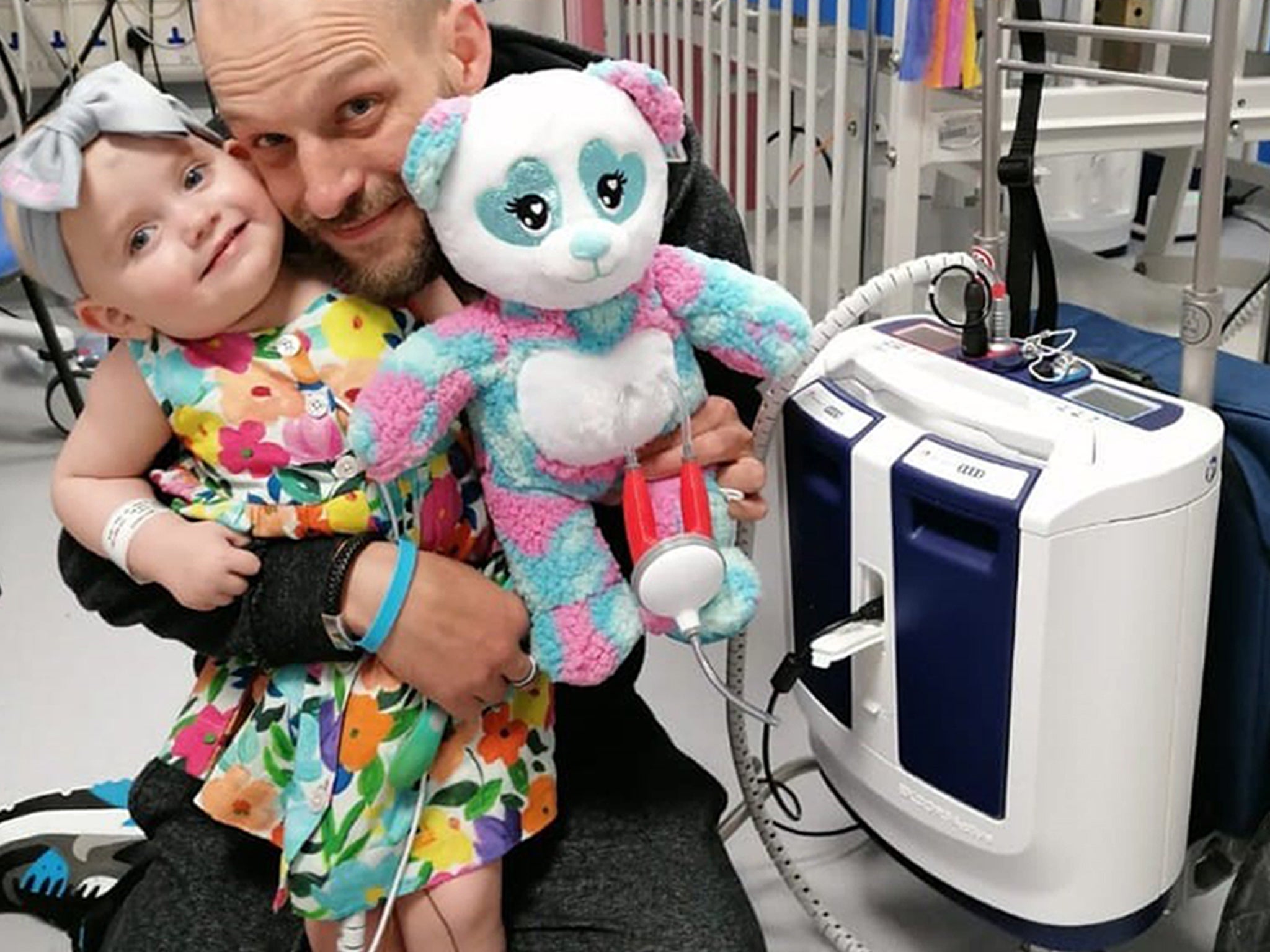 Baby Grace with father Darren and her new portable heart pump