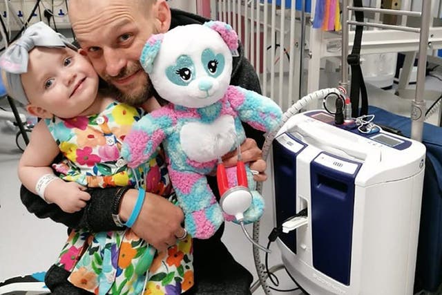<p>Baby Grace with father Darren and her new portable heart pump</p>