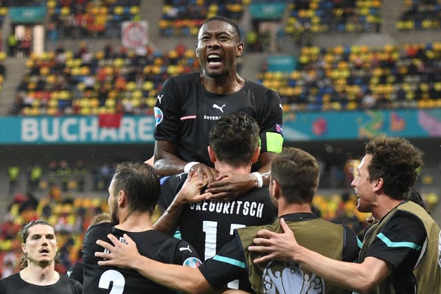 <p>Austria captain David Alaba (top) celebrates with his team-mates</p>