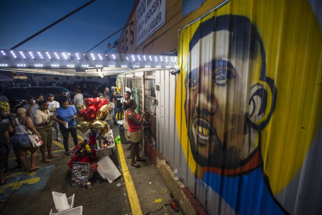 <p>Protesters gather outside a mural of Alton Sterling in July 2016</p>