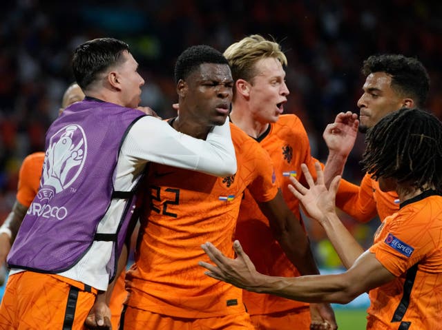 <p>Netherlands players celebrate with match-winner Denzel Dumfries</p>