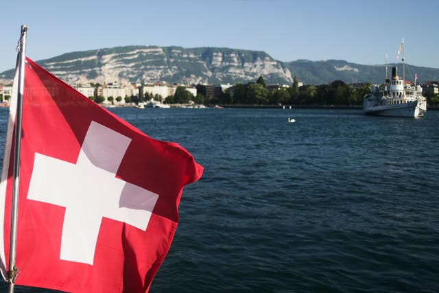 <p>The Swiss national flag flutters over Lake Geneva in Switzerland</p>