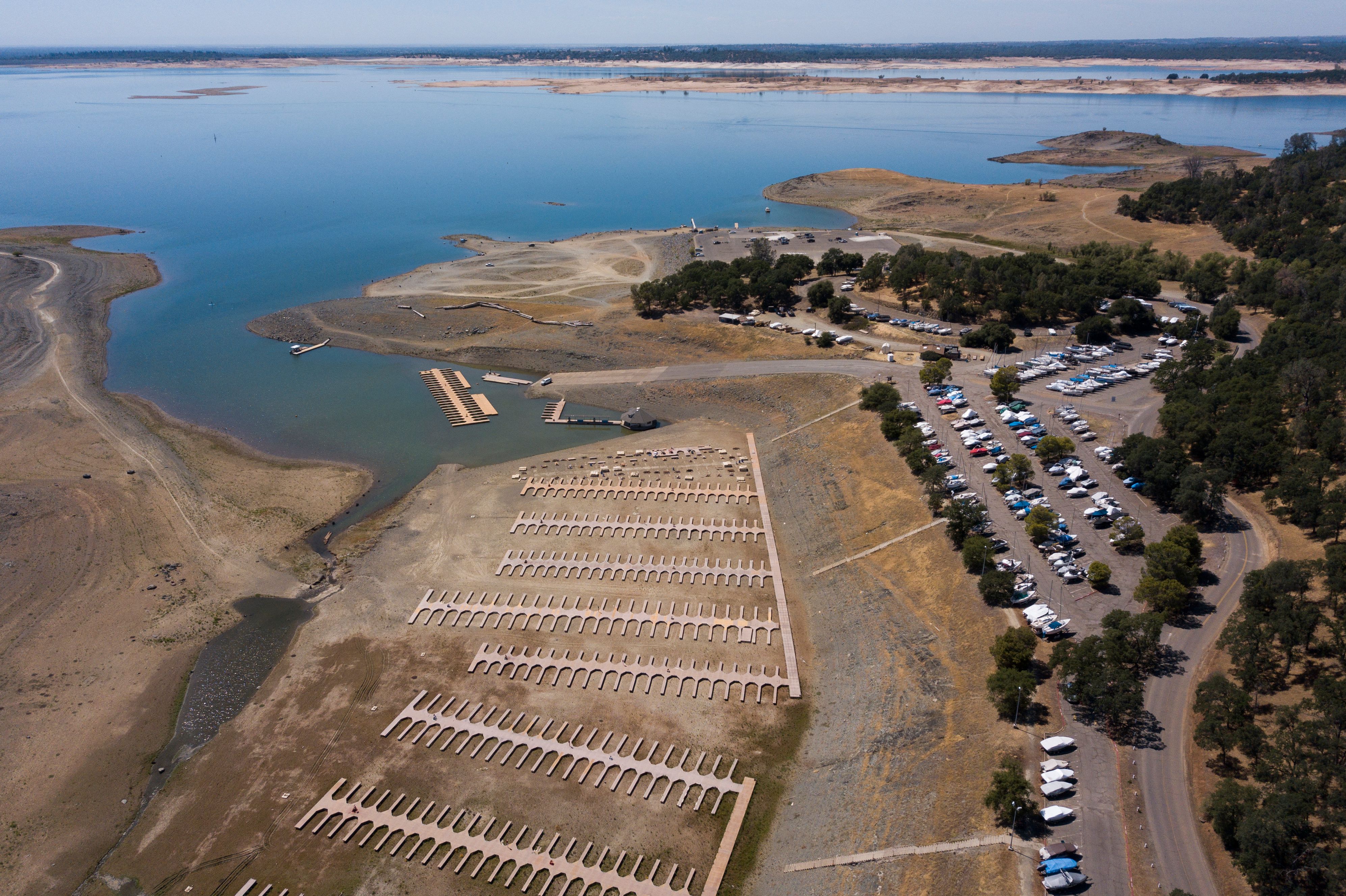 An aerial image shows boats stored in a parking lot after the Folsom Lake Marina closed due to dry lake bed conditions during the California drought emergency on May 27, 2021 in El Dorado Hills, California. A plane wreckage found at the bottom of the lake could solve a decades-old mystery.