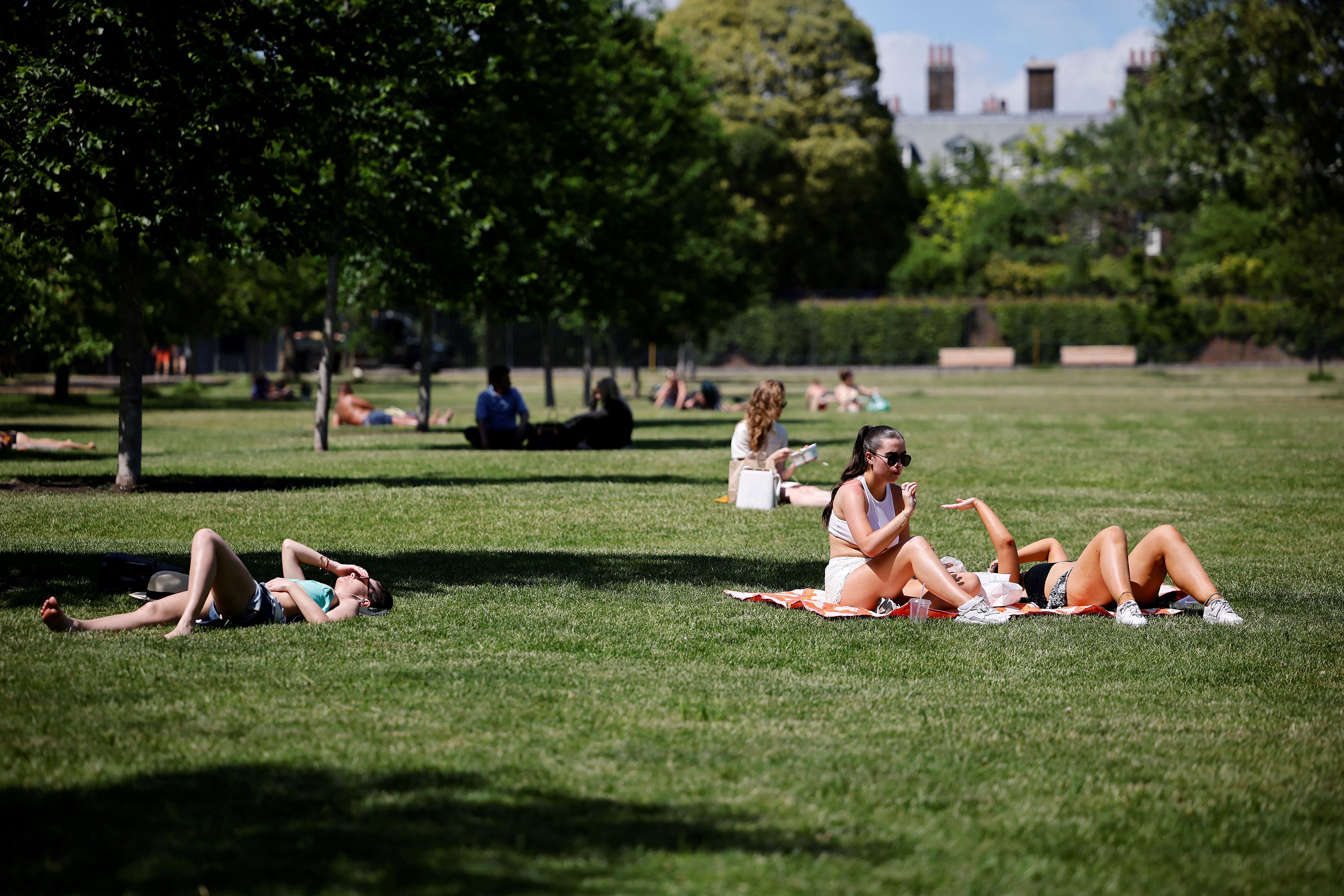 People enjoy the sunshine in Hyde Park in London where temperatures rose to scorching levels