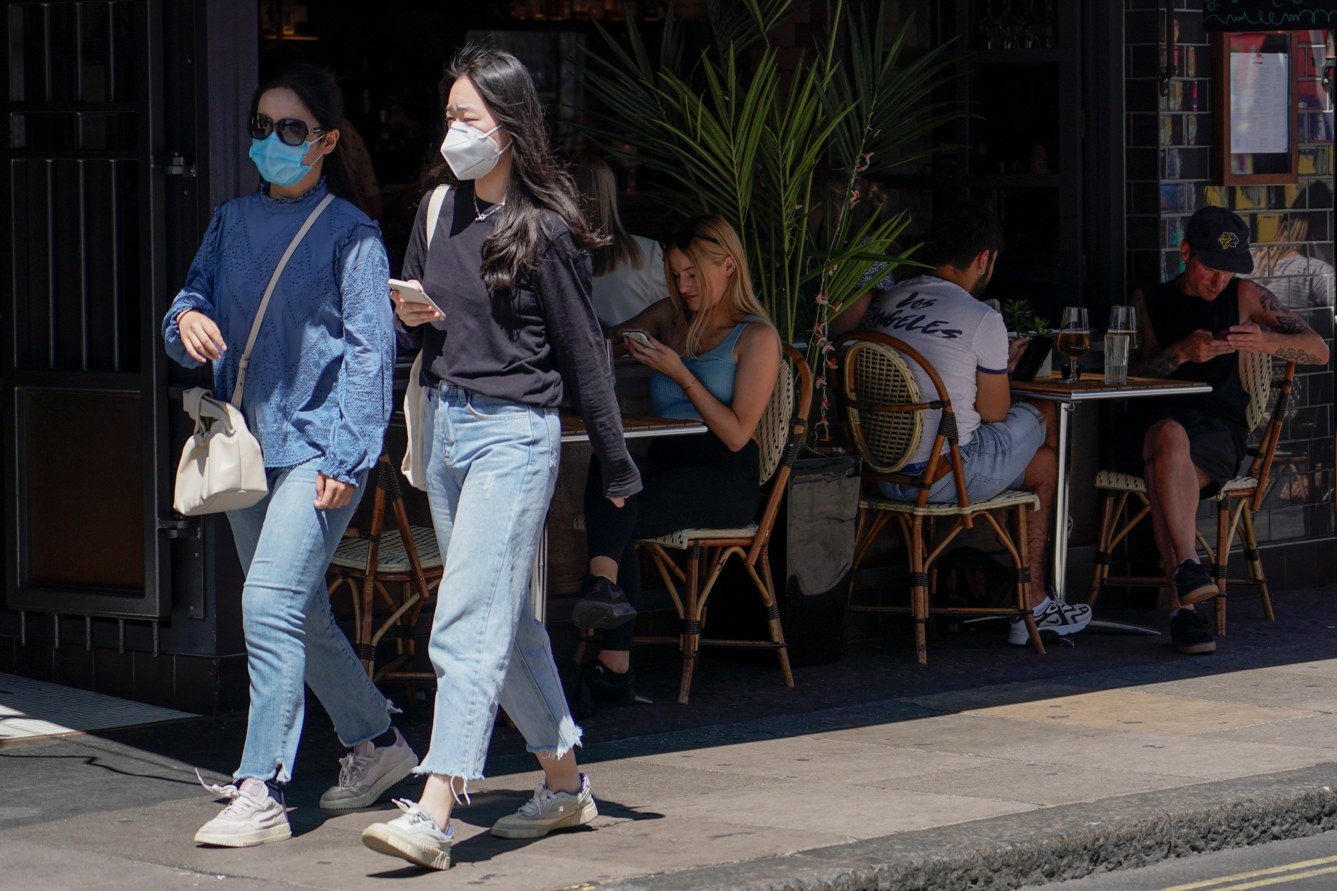 People sit at outdoor tables at a restaurant in Soho, in London, on Monday as coronavirus cases hit the highest daily rate since February.