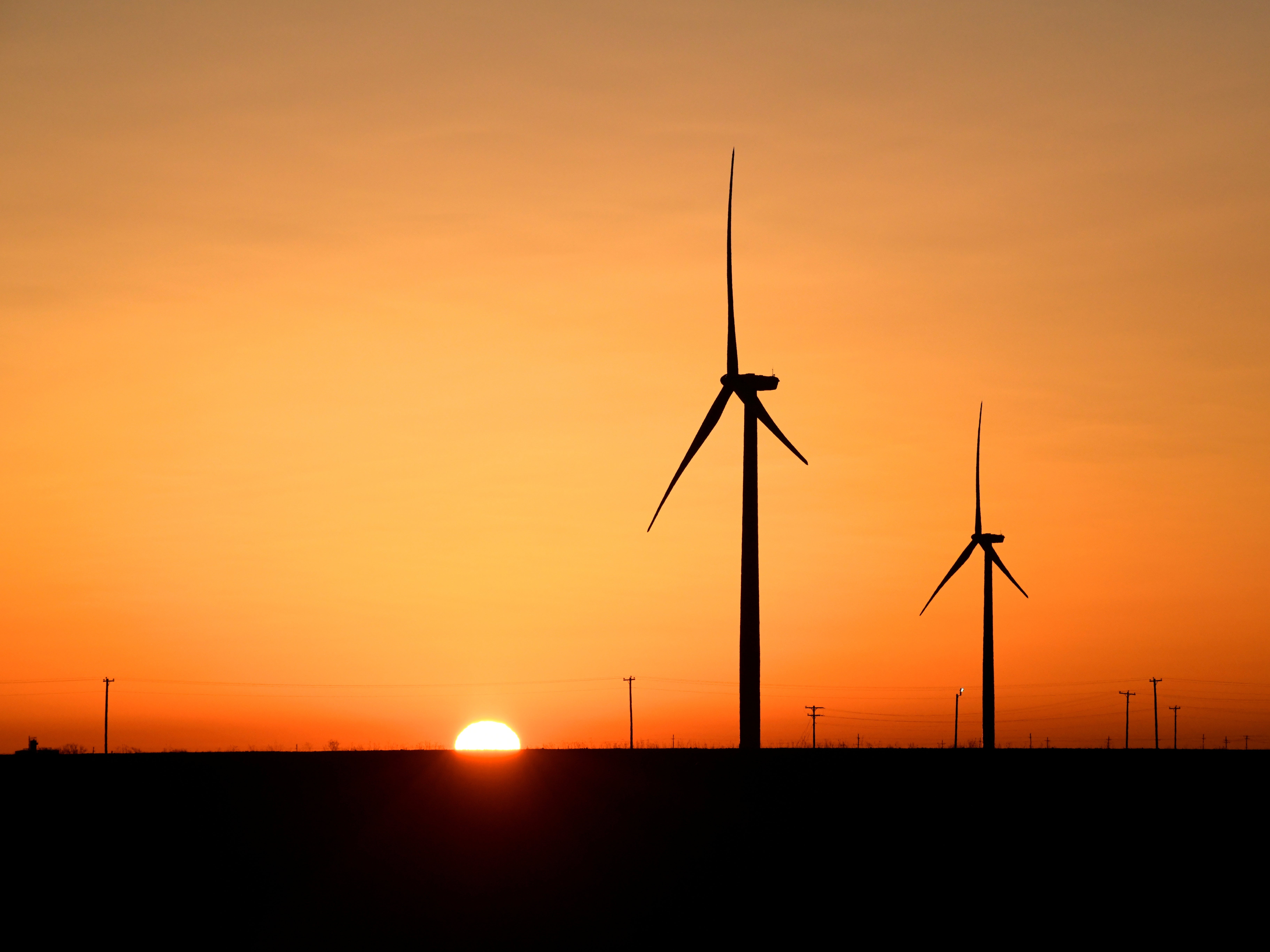 Wind turbines operate at sunrise in the Permian Basin oil and natural gas production area in Big Spring, Texas, 12 February, 2019. REUTERS/Nick Oxford