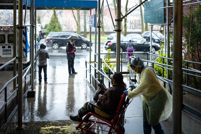 <p>Un miembro del personal empuja a un paciente en silla de ruedas en el Hospital St Barnabas el 23 de marzo de 2020 en el barrio del Bronx de la ciudad de Nueva York.</p>