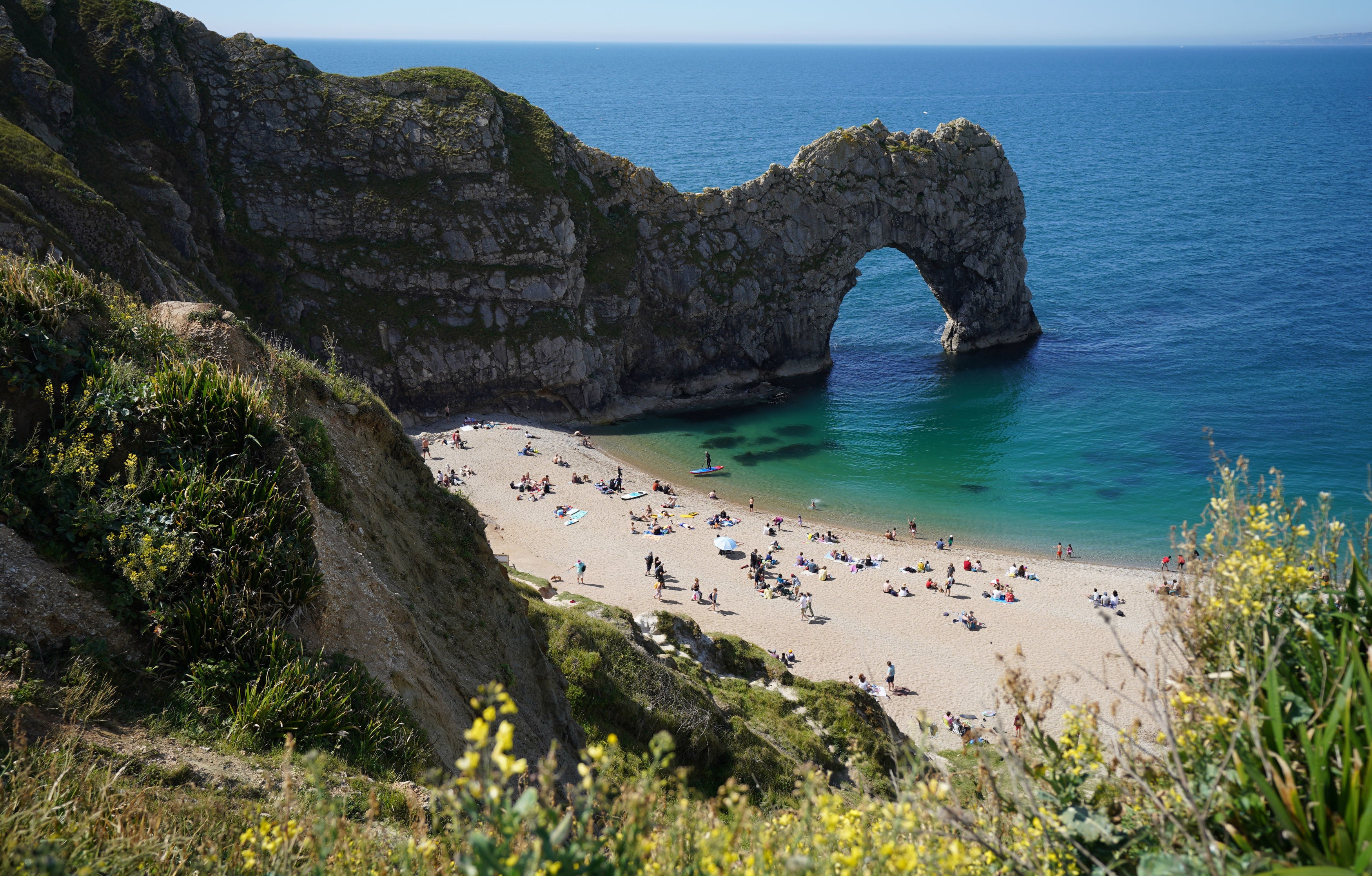 Dorset Police said the woman, who has not been identified, was pronounced dead at the scene (pictured: Durdle Door in early June)