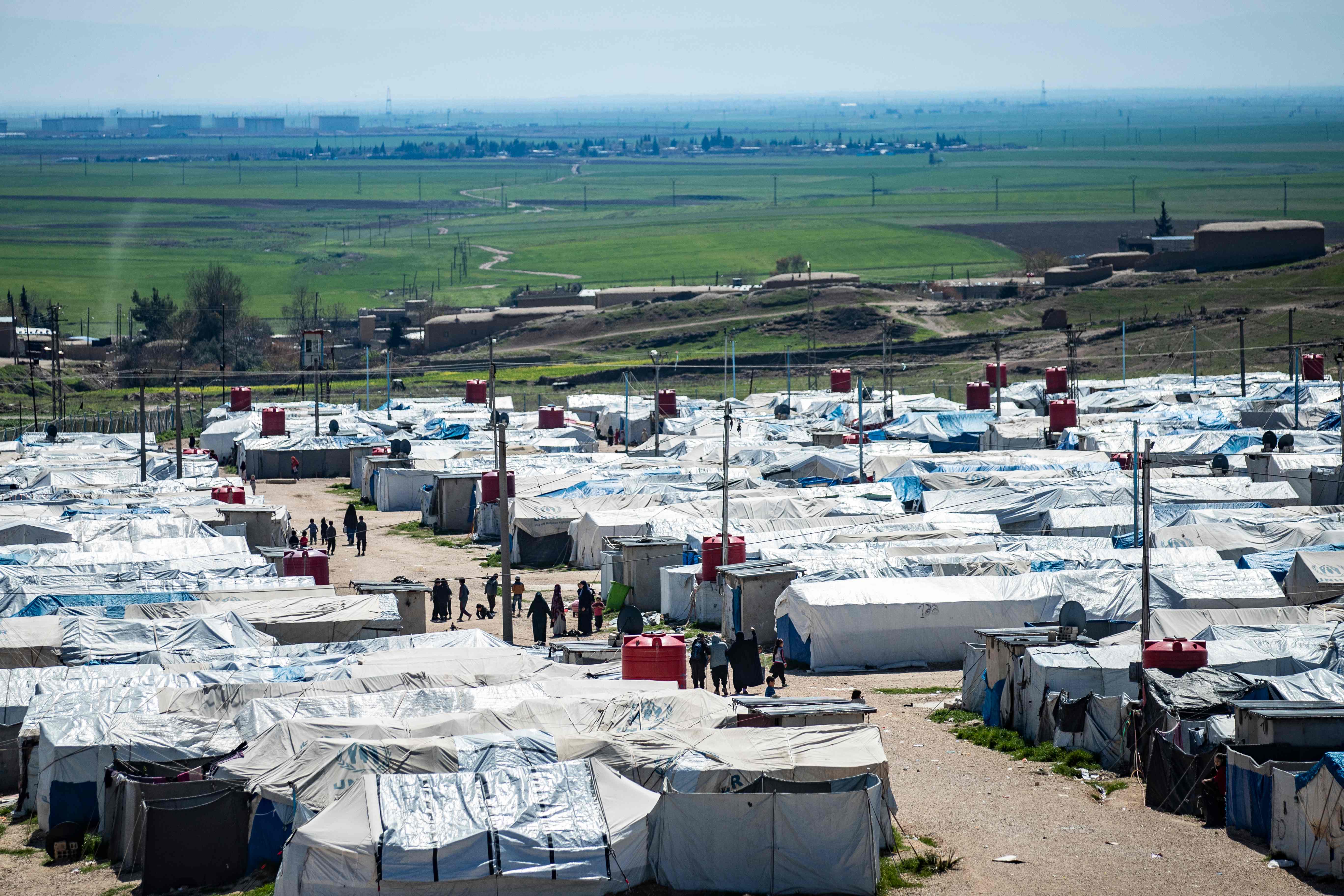 Women and children walk at Camp Roj, where relatives of people suspected of belonging to Isis are held