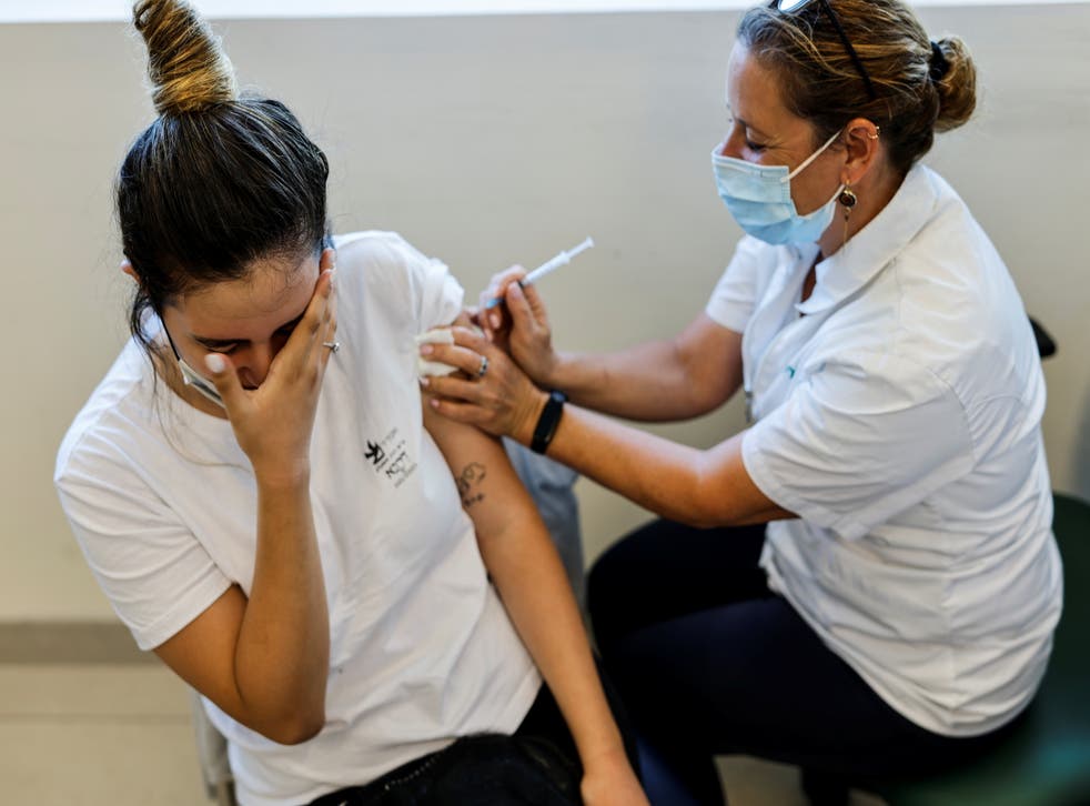 <p>A teenager receives a dose of a Covid vaccine in Ashkelon, Israel</p>