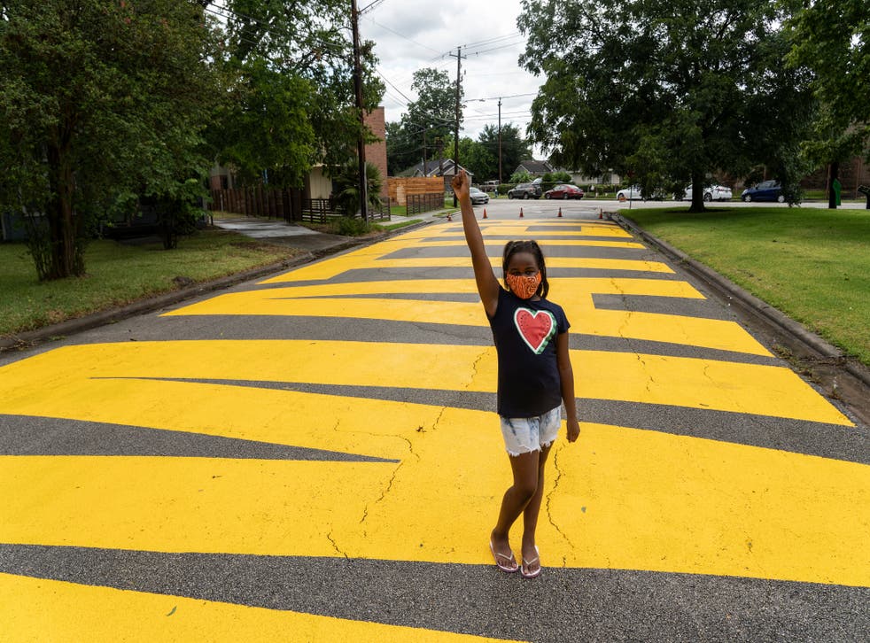 <p>Kainaan Jones, 9, poses on ‘Black Towns Matter’ painted on a street on 19 June, 2020 in Houston, Texas.</p>