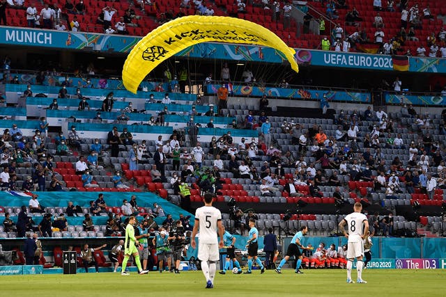 <p>A "Greenpeace" protester is seen flying into the stadium prior to the UEFA Euro 2020 Championship Group F match between France and Germany at Football Arena Munich on June 15, 2021 in Munich, Germany.</p>